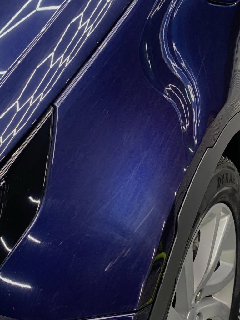 Paint correction in progress on deep blue paintwork