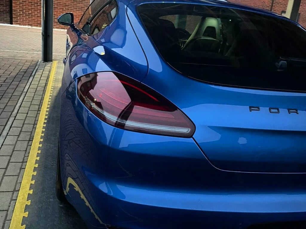 Blue Porsche Panamera rear quarter with mirror reflections